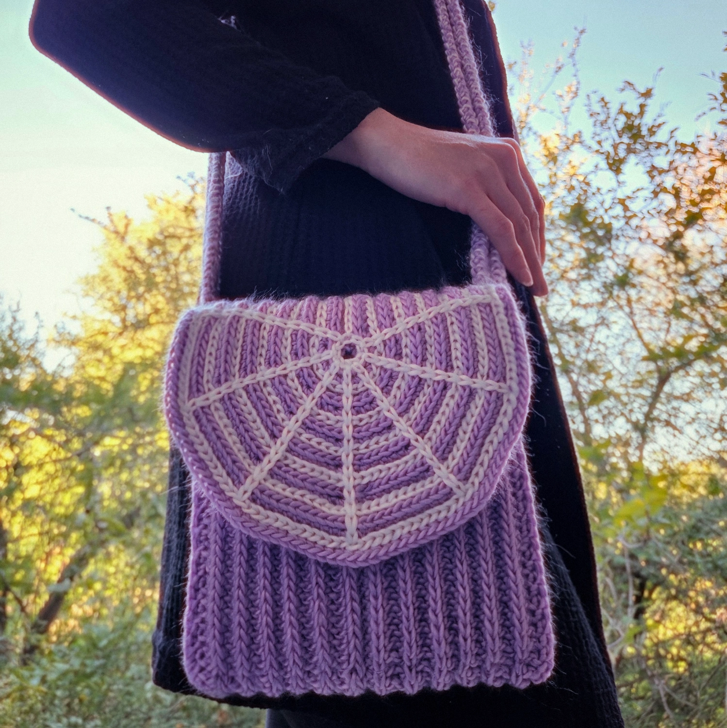 Purple crocheted crossbody bag with a white spiderweb detail